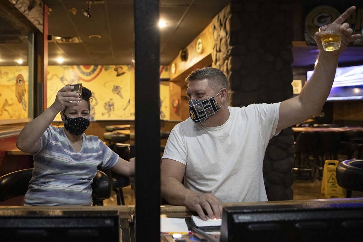 John Adler, right, and Norma Jean Aguilar lift their glasses during a last call toast at Jackso ...