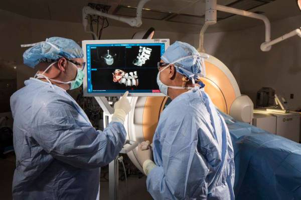Certified surgical technicians Jay French, left, and Rodney Haynes examine mock 3-D images take ...