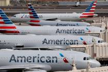 FILE - In this March 25, 2020, file photo, American Airlines jets sit idly at their gates as a ...