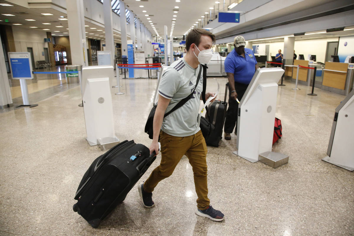 FILE - In this April 30, 2020, file photo, Ethan Cale walks to the American Airlines ticket cou ...