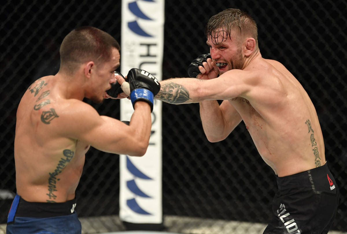 (R-L) Tim Elliott punches Ryan Benoit in their flyweight fight during the UFC Fight Night event ...