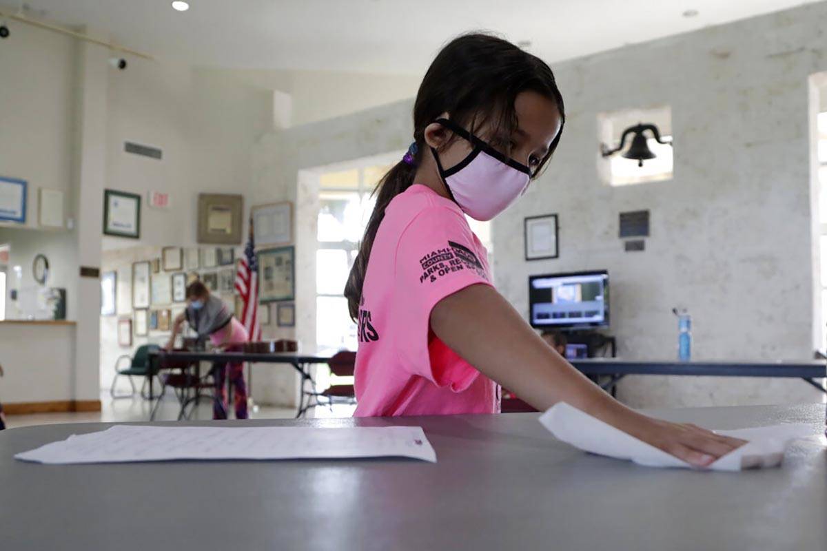 Valentina Fasano cleans her work space with sanitizing wipes at the Girl's Empowerment and Ment ...