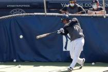 With coaches looking on, New York Yankees' Gleyber Torres bats in the cage during baseball summ ...