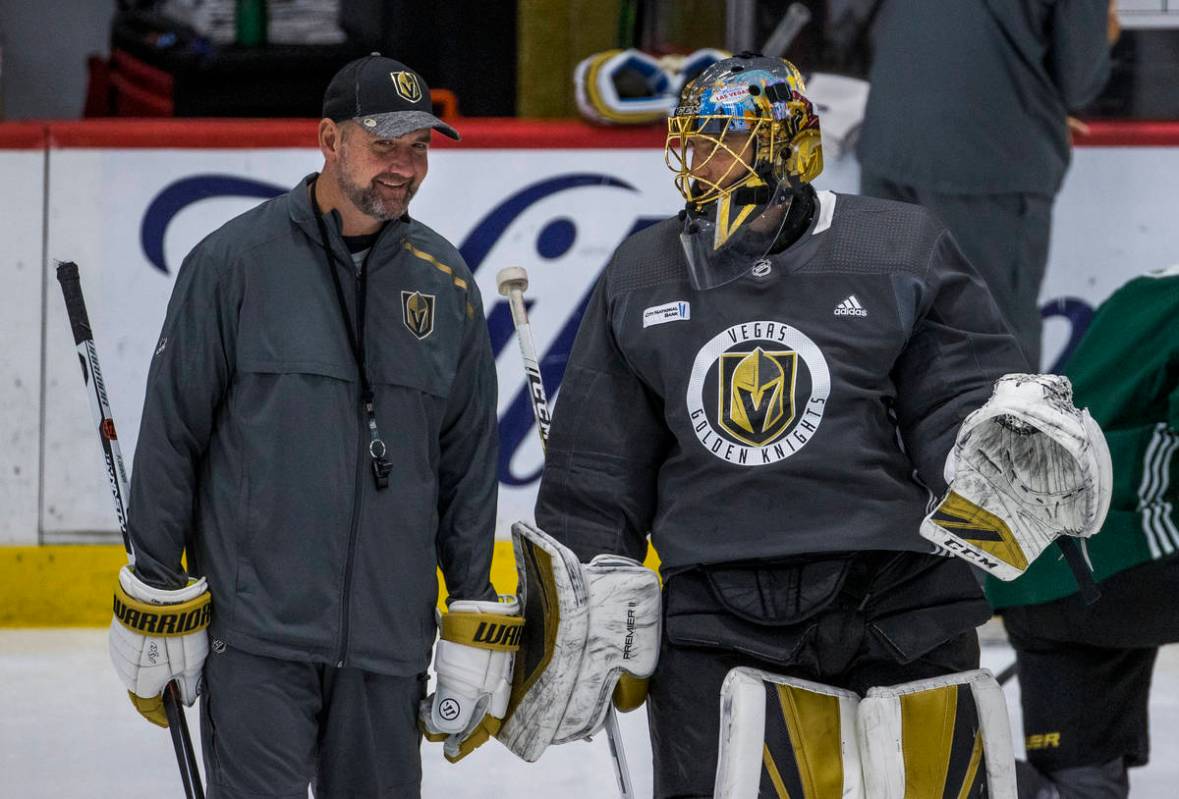 Vegas Golden Knights head coach Peter DeBoer, left, chats on the ice with goaltender Marc-Andre ...