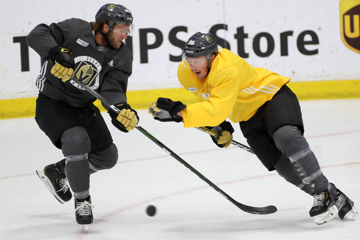 Vegas Golden Knights Jake Bischoff, left, and Patrick Brown, compete for the puck during a team ...