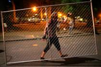 Protesters relocate a fence in front of the Justice Center, Saturday, July 18, 2020, during ano ...