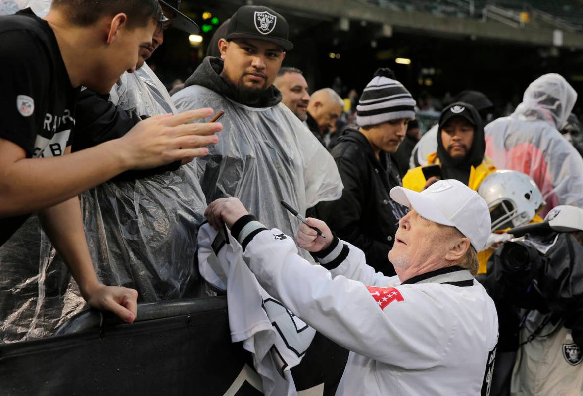 Oakland Raiders owner Mark Davis signs autographs for fans before an NFL football game between ...