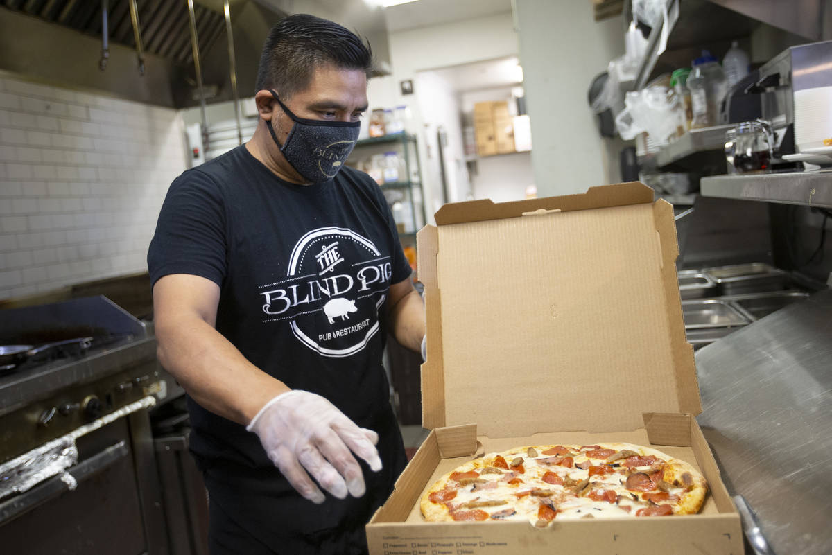 Chef Armando Pescuul puts a meat lovers pizza from Vegas.Pizza into a to-go box at The Blind Pi ...