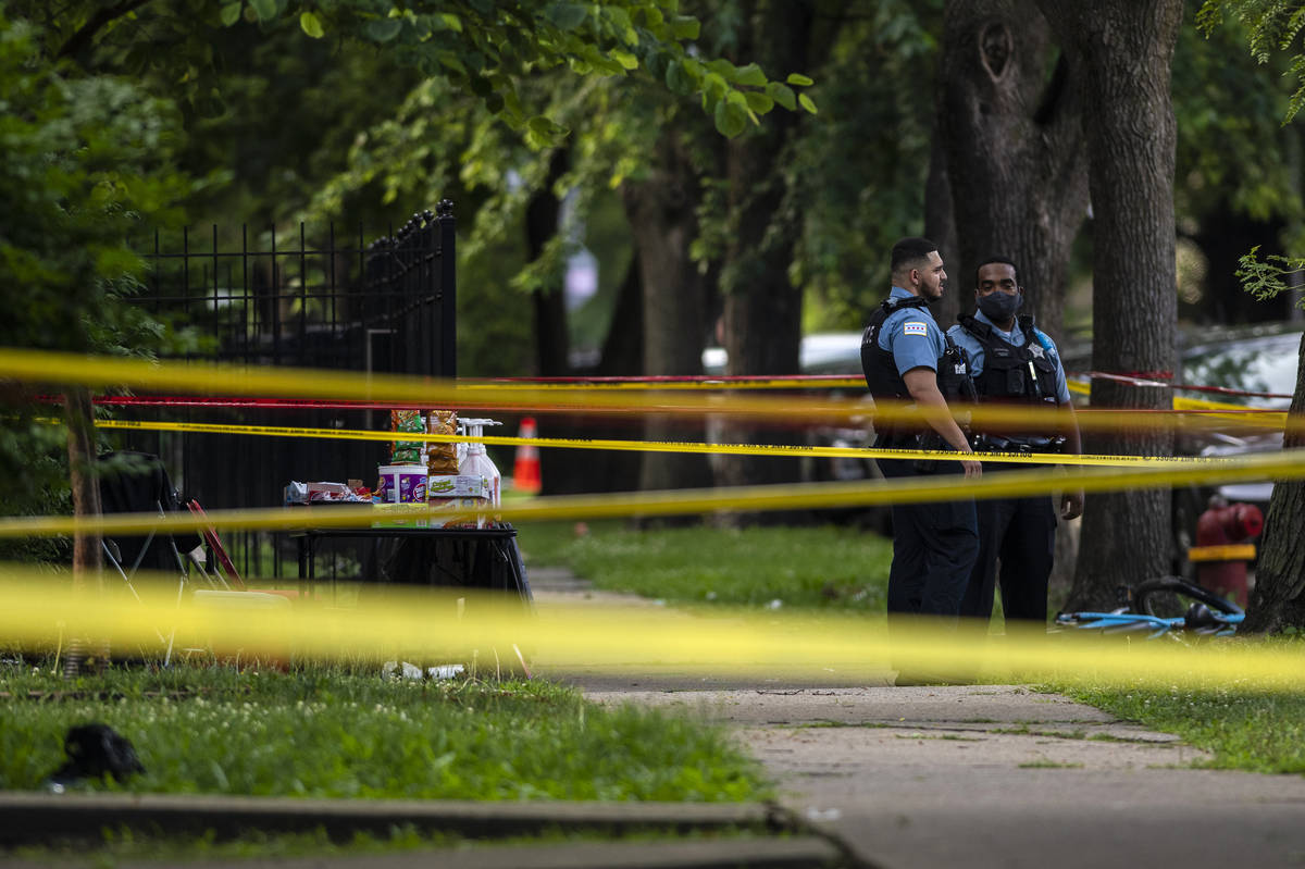 Chicago police investigate the scene where multiple people were shot in the 8200 block of South ...