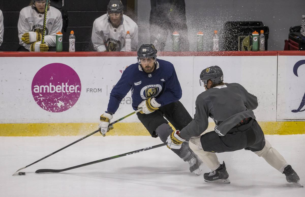 Vegas Golden Knights right wing Alex Tuch (89, left) works for control of the puck from defense ...