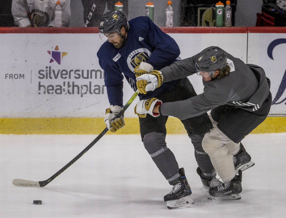 Vegas Golden Knights right wing Alex Tuch (89, left) battles for control of the puck from defen ...
