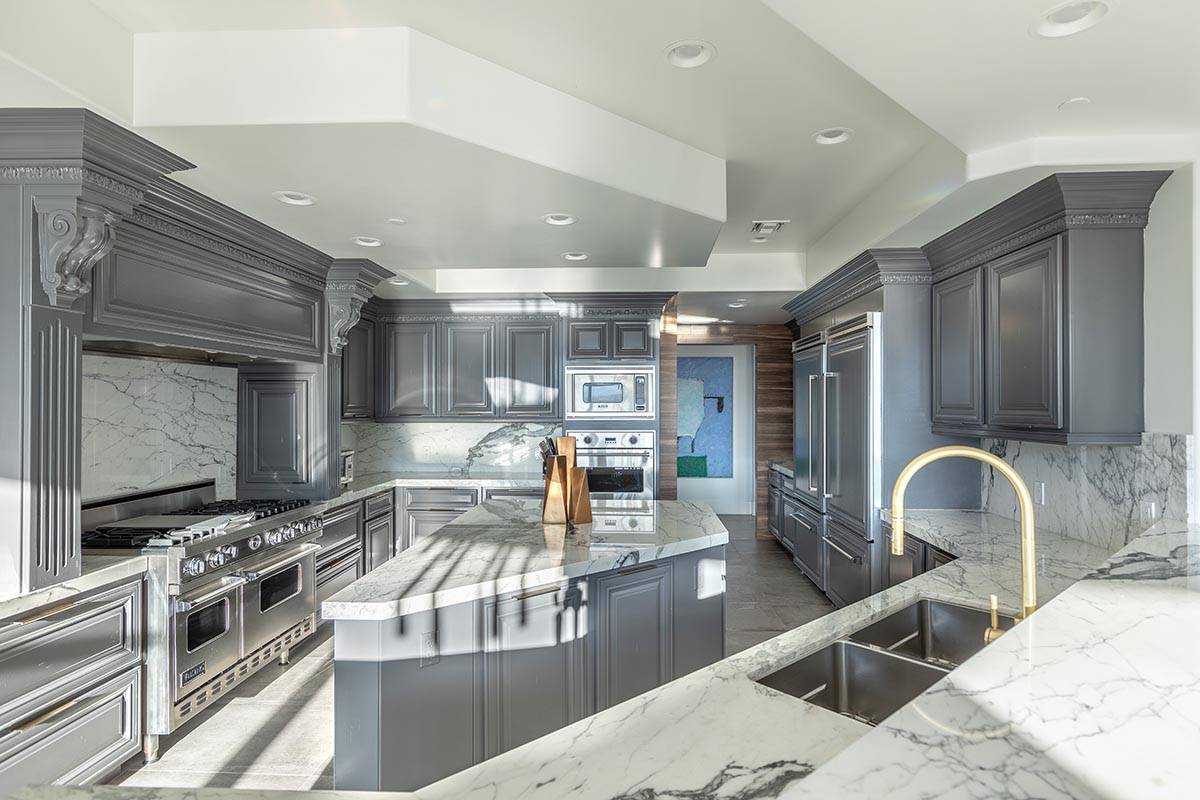 The kitchen at this One Queensridge Place condo features upgraded appliance.s (Char Luxury Real ...