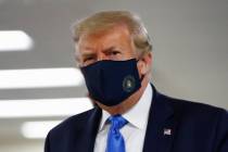 In this July 11, 2020, file photo President Donald Trump wears a face mask as he walks down a h ...