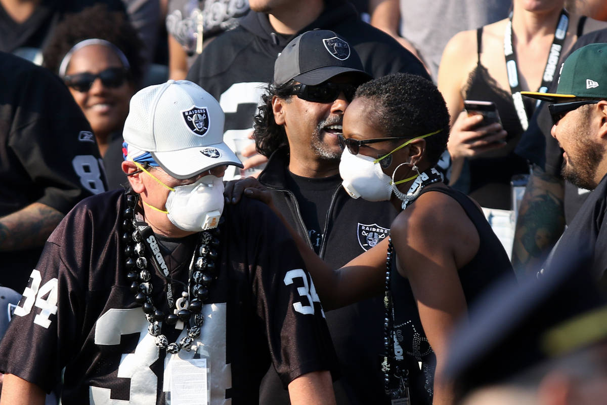Oakland Raiders fans wear masks due to a smoky environment caused by the Camp Fire north of the ...