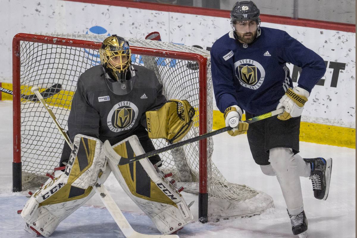 Vegas Golden Knights goaltender Marc-Andre Fleury (29, left) defends the net as right wing Alex ...