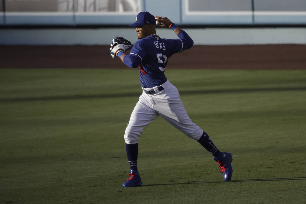 Los Angeles Dodgers right fielder Mookie Betts throws after catching a fly ball during the firs ...