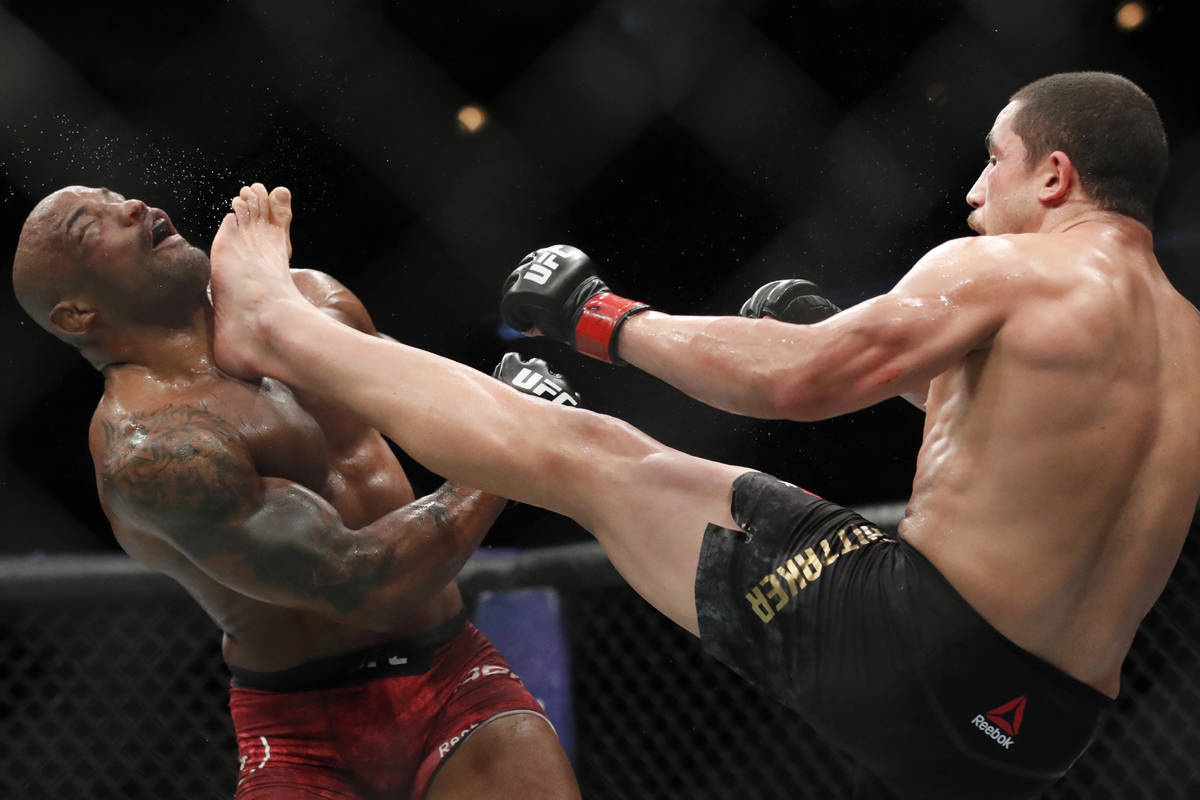 Robert Whittaker, right, kicks Yoel Romero in the face during their middleweight title mixed ma ...