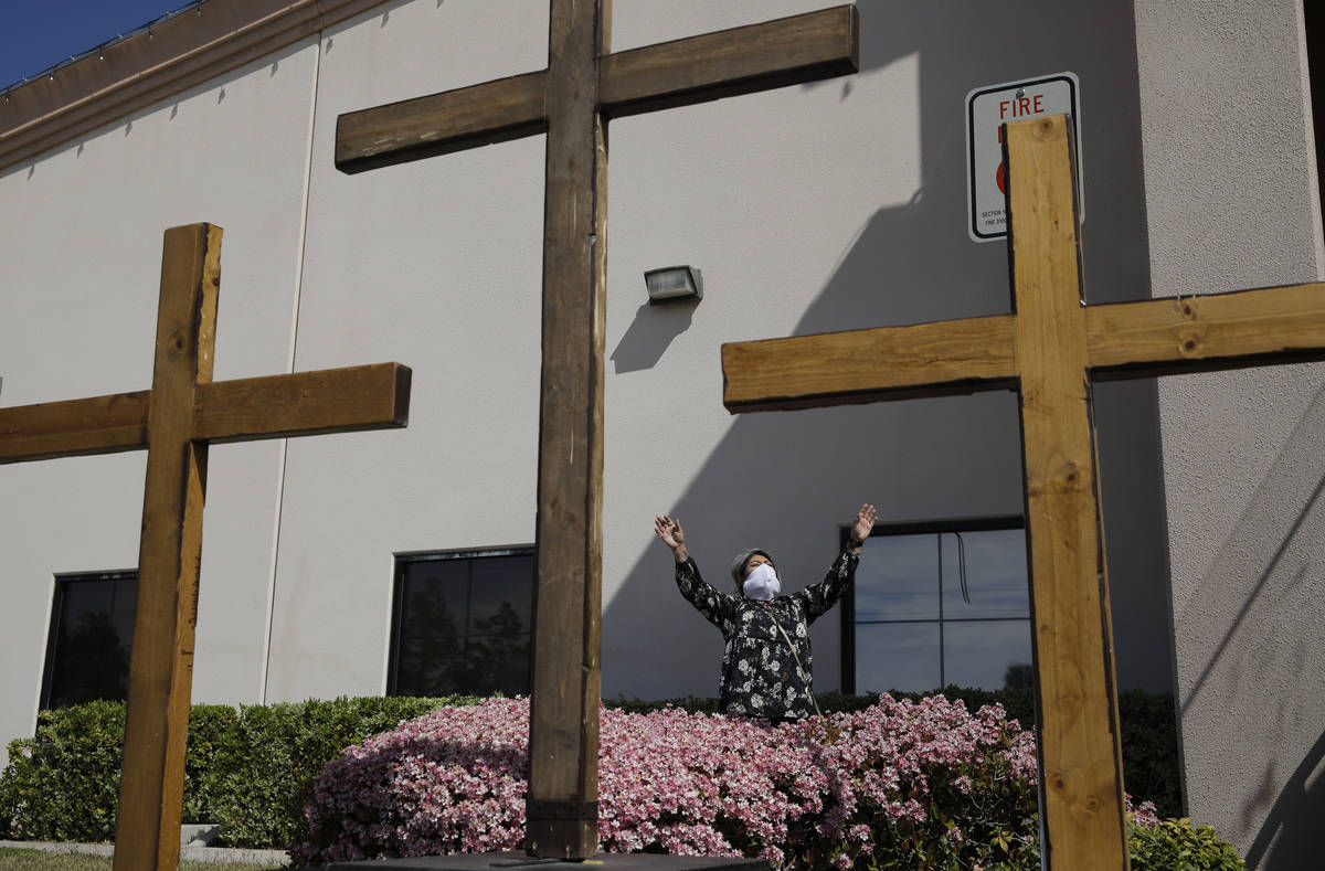 Norma Urrabazo prays while wearing a facemask before speaking at an Easter drive-in service at ...