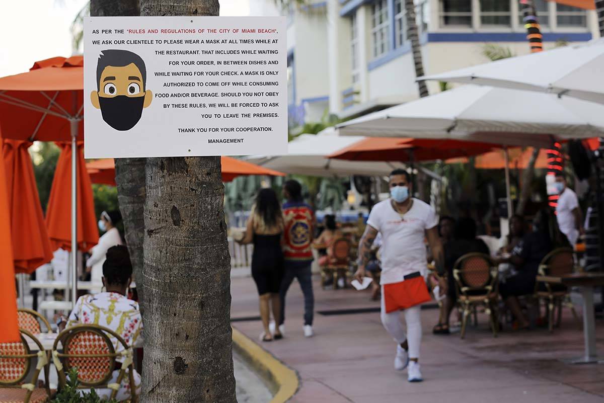 A sign informs customers at the Edison Hotel restaurant about wearing a protective face mask du ...