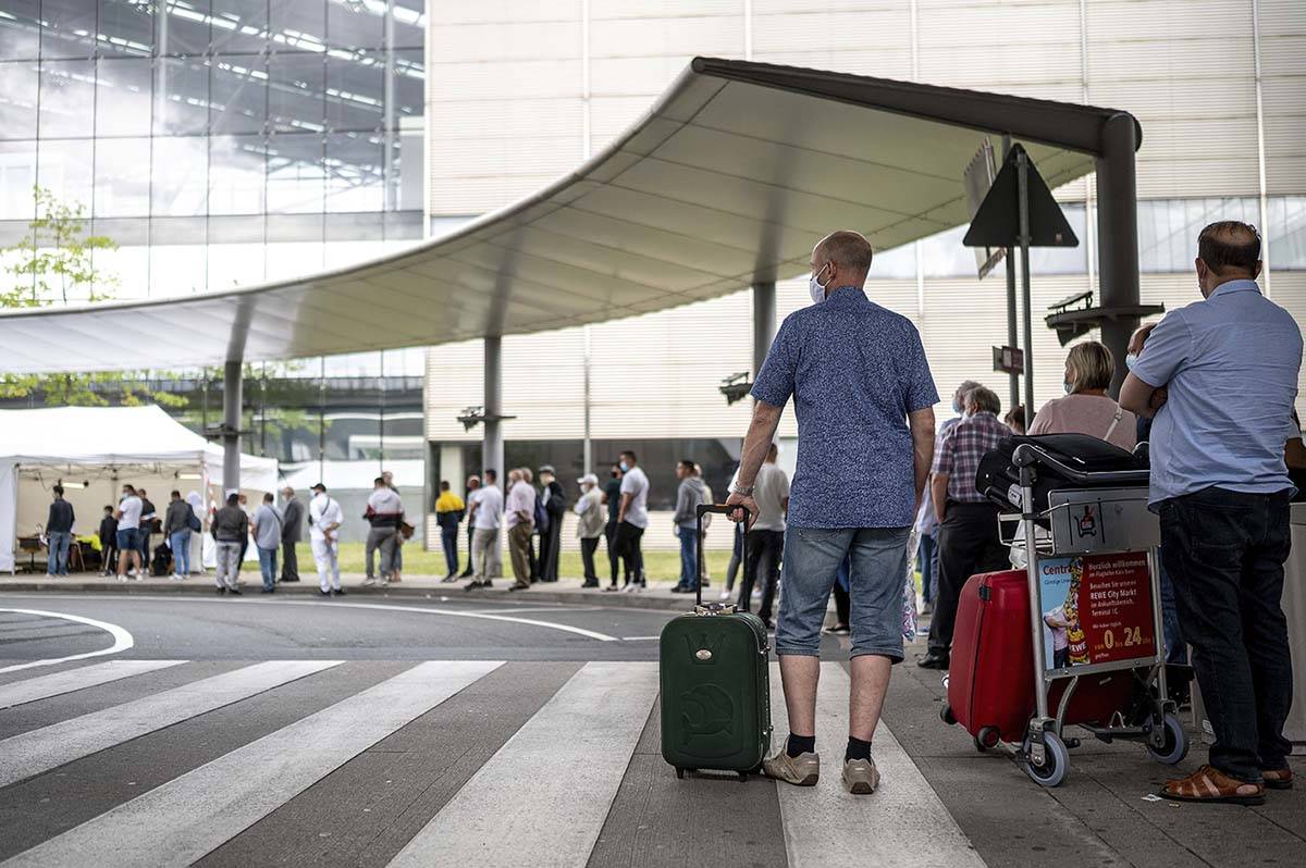 Travellers queue up at the test station for the coronavirus at Cologne/Bonn Airport in Cologne, ...