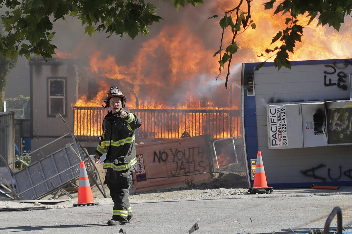 Construction buildings burn near the King County Juvenile Detention Center, Saturday, July 25, ...
