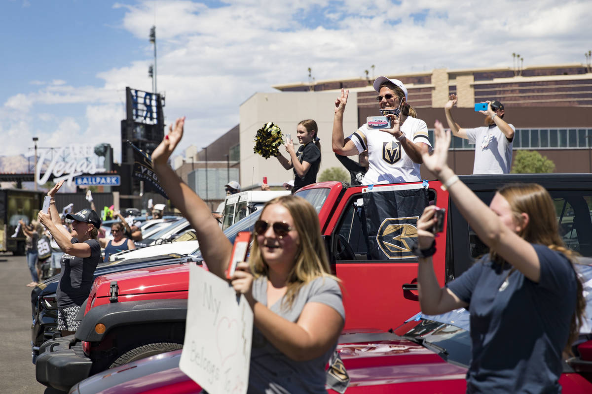 Fans wave at buses of the Golden Knights players as they leave for Canada as part of NHL's retu ...
