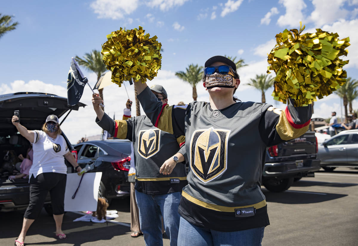 Louisa Moore waves pom poms cheering for the Golden Knights players as they pass in buses befor ...