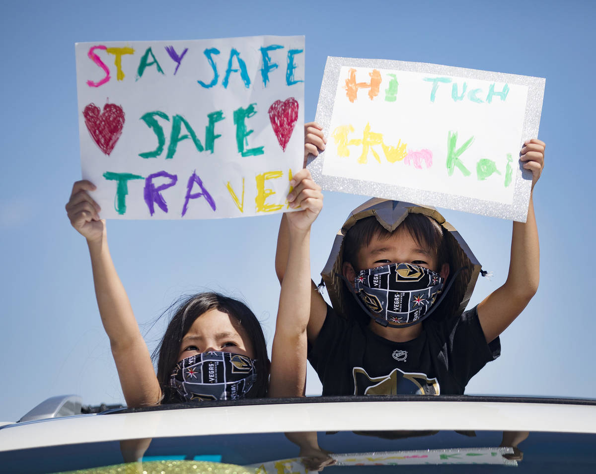 Emi Yoshikawa, 7, left, and her brother Kai Yoshikawa, 5, right, hold signs as they wait for th ...
