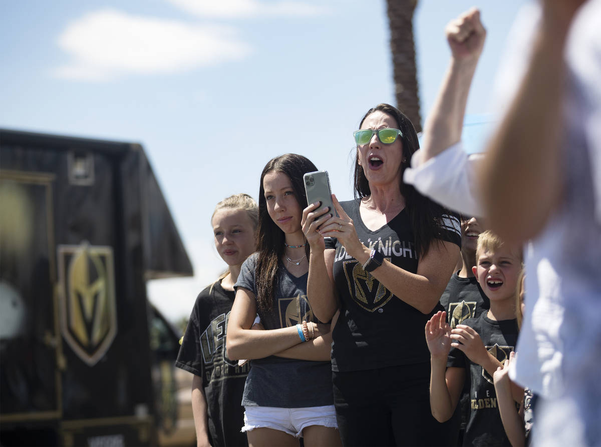 Fans wave at buses of the Golden Knights players as they leave for Canada as part of NHL's retu ...