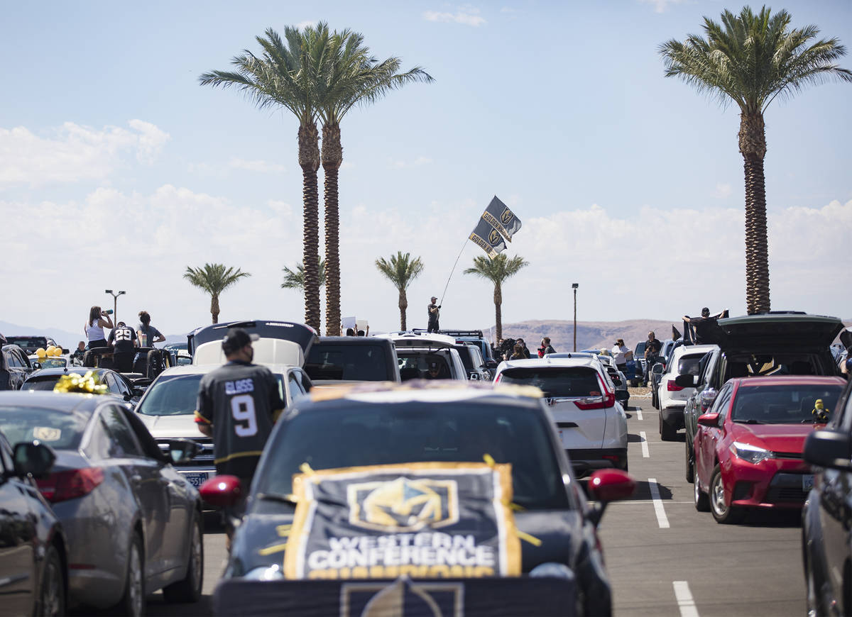 Fans wait in parked cars for Golden Knights players to pass in buses before they leave for Cana ...