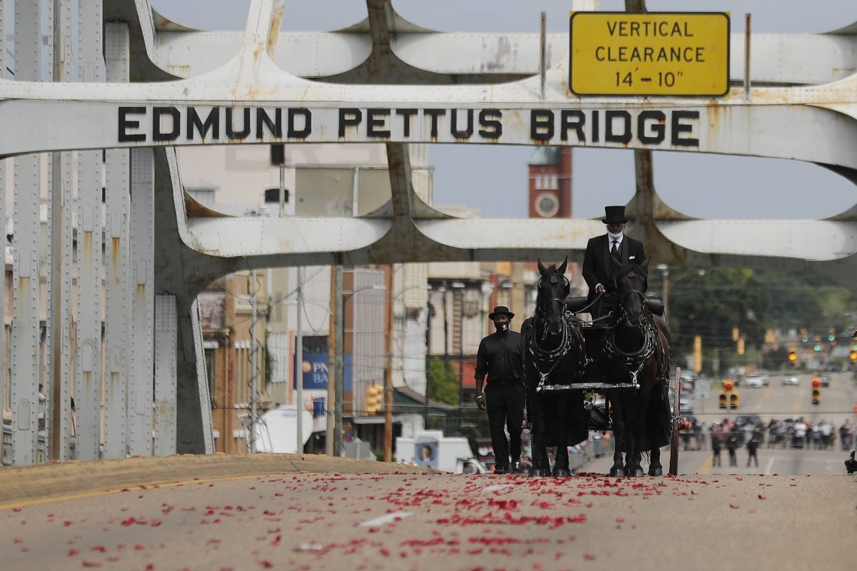 The casket of Rep. John Lewis moves over the Edmund Pettus Bridge by horse-drawn carriage durin ...