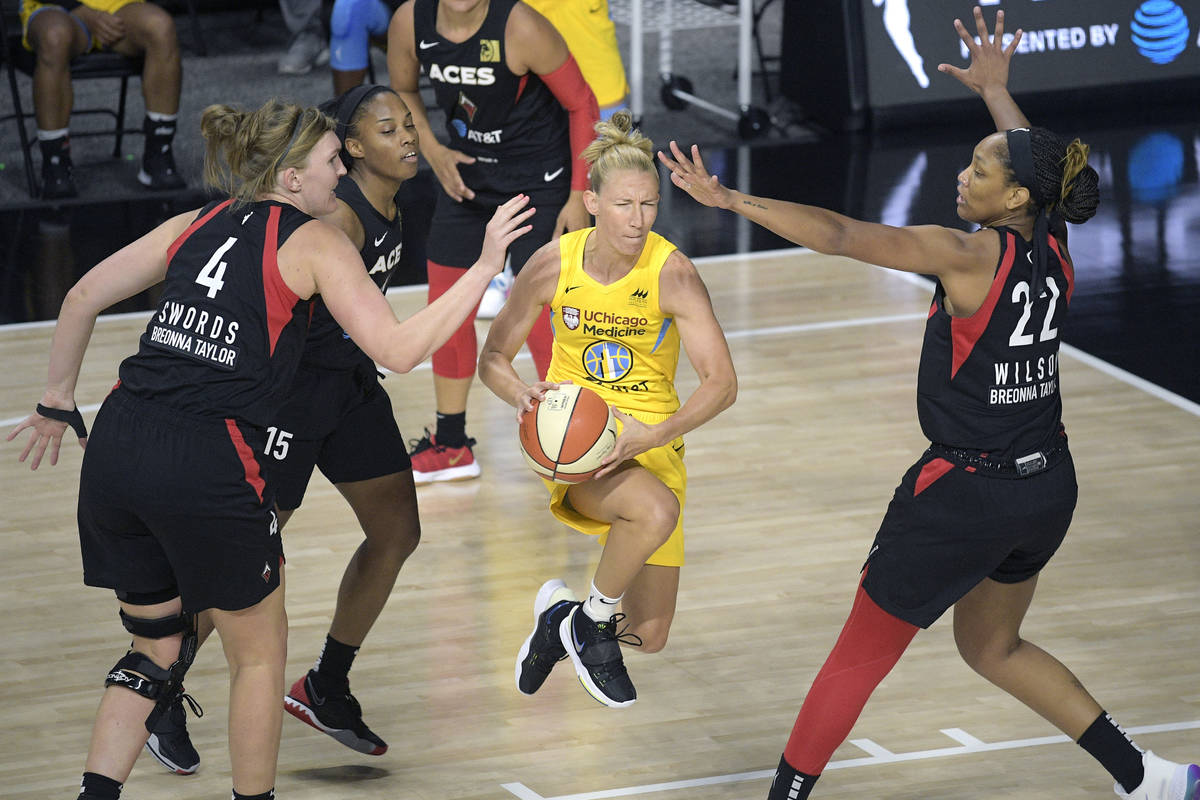 Chicago Sky guard Courtney Vandersloot, center, drives between Las Vegas Aces center Carolyn Sw ...