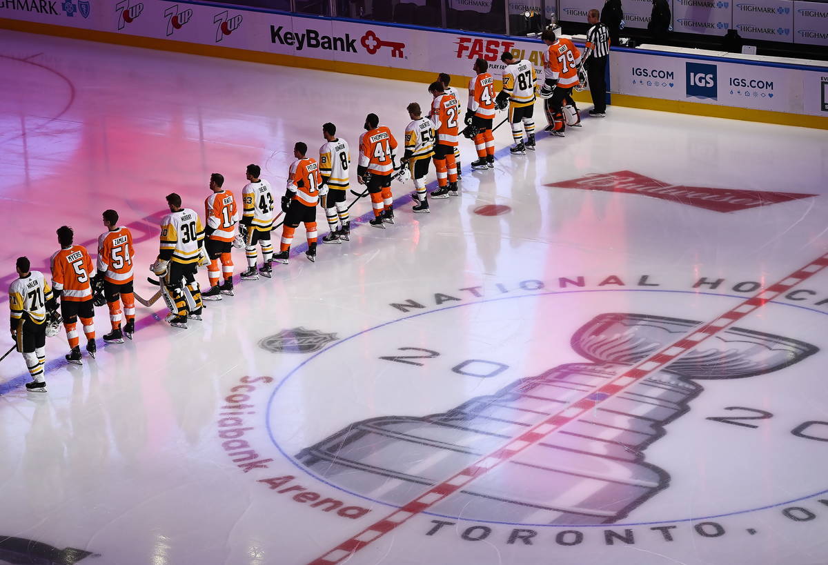 The Pittsburgh Penguins and Philadelphia Flyers line up together for the national anthems befor ...