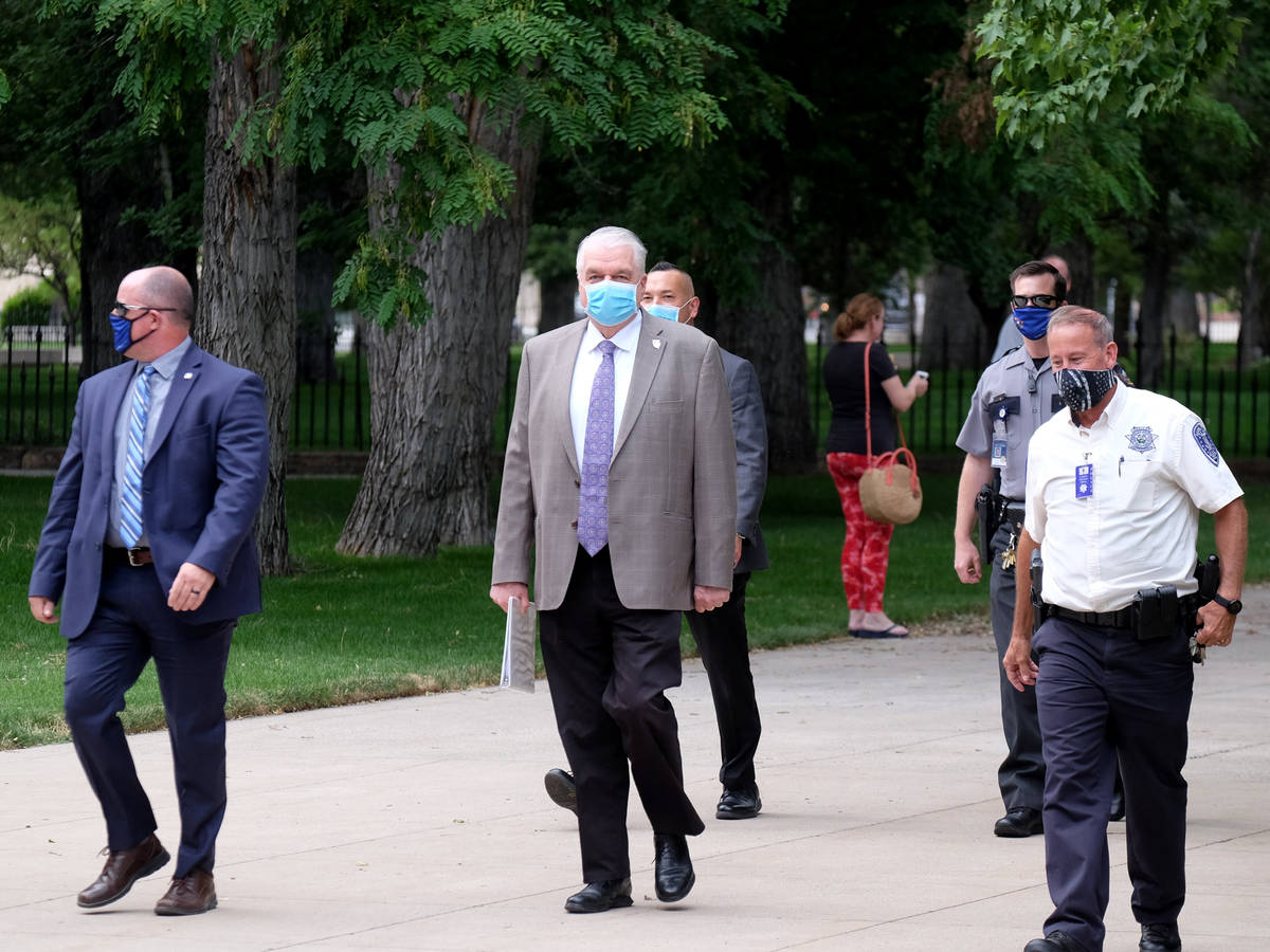 Gov. Steve Sisolak walks from the Capitol to the Legislative building to give a press briefing ...