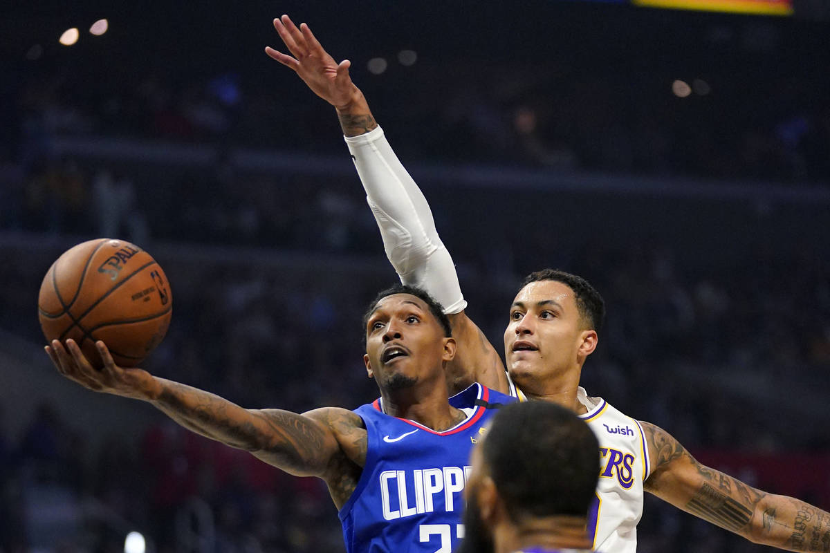 Los Angeles Clippers guard Lou Williams, left, shoots as Los Angeles Lakers forward Kyle Kuzma ...