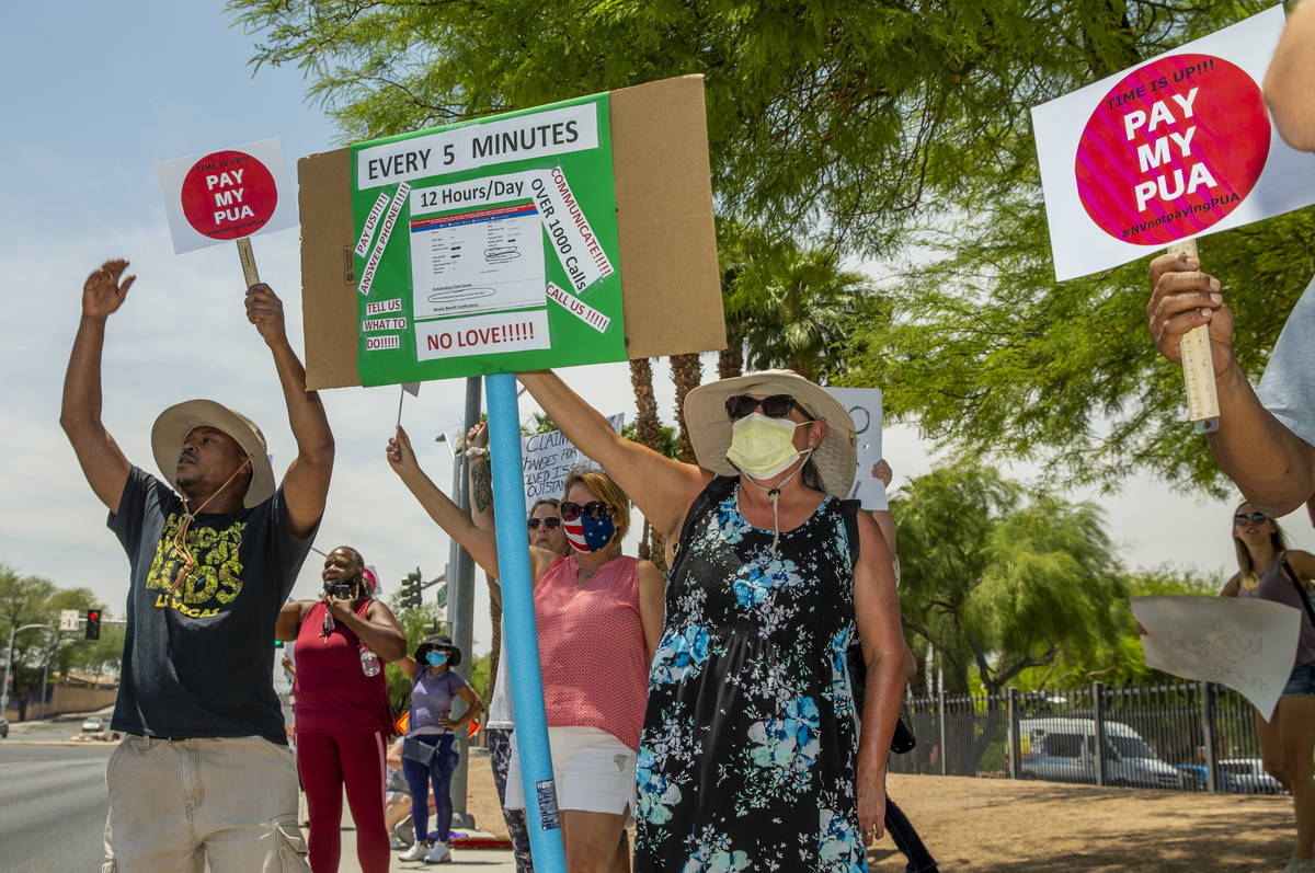 Gig workers gather with signs and wave to passing motorists to protest the Nevada unemployment ...