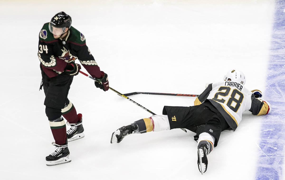 Arizona Coyotes' Carl Soderberg (34) drags Vegas Golden Knights' William Carrier (28) across th ...