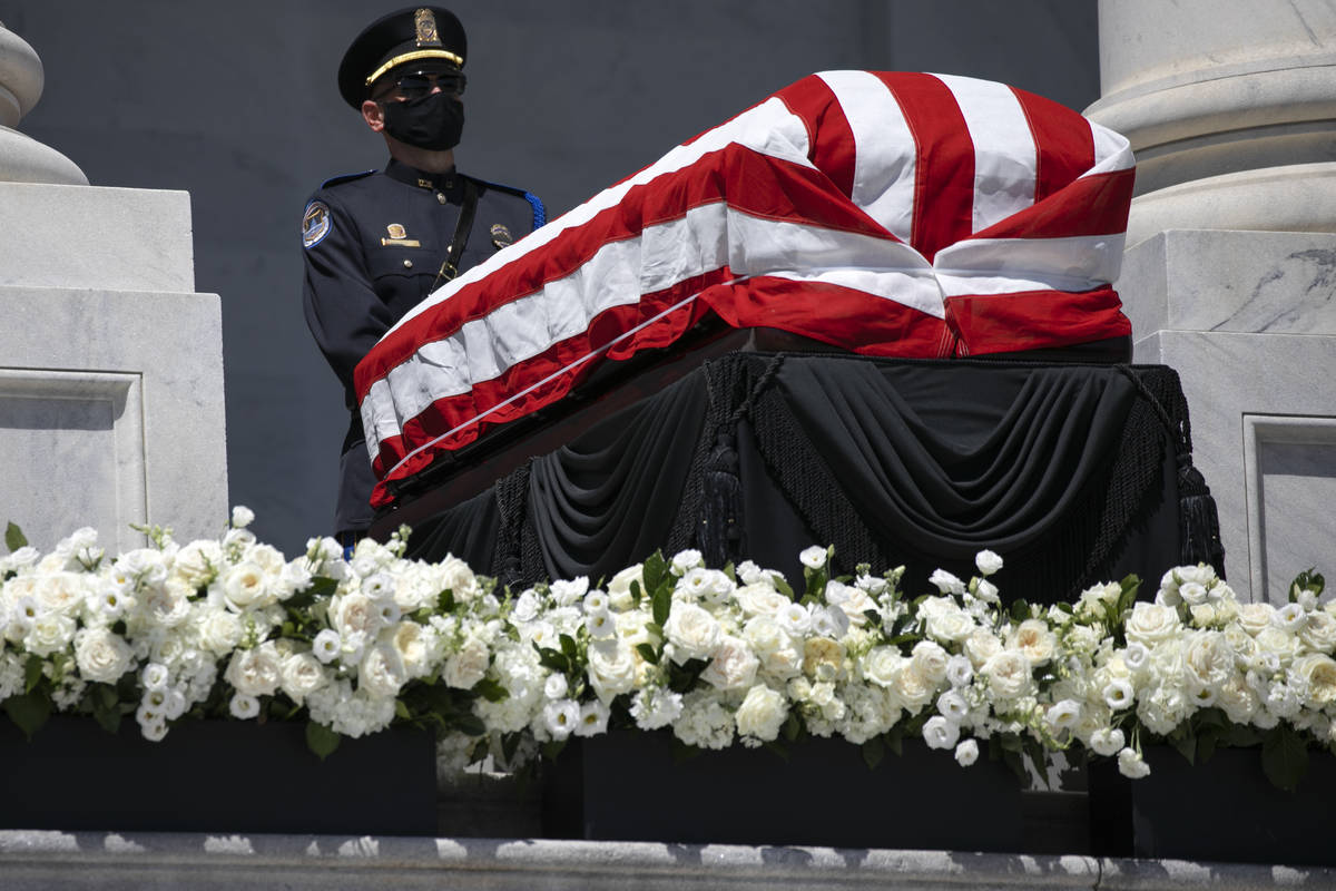 An officer guards the flag-draped casket of Rep. John Lewis, D-Ga., as he lies in state on the ...