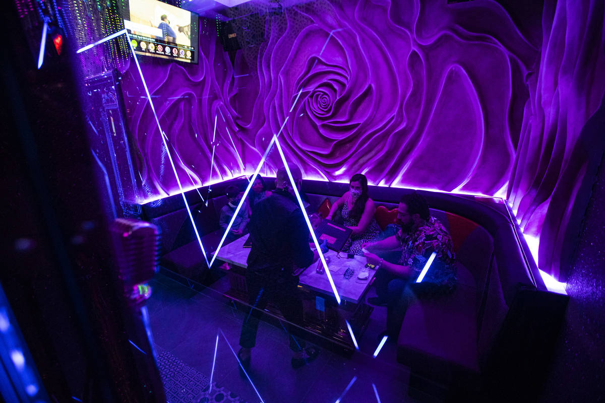 A server assists guests as they arrive in their room at Kamu Karaoke at the Grand Canal Shoppes ...