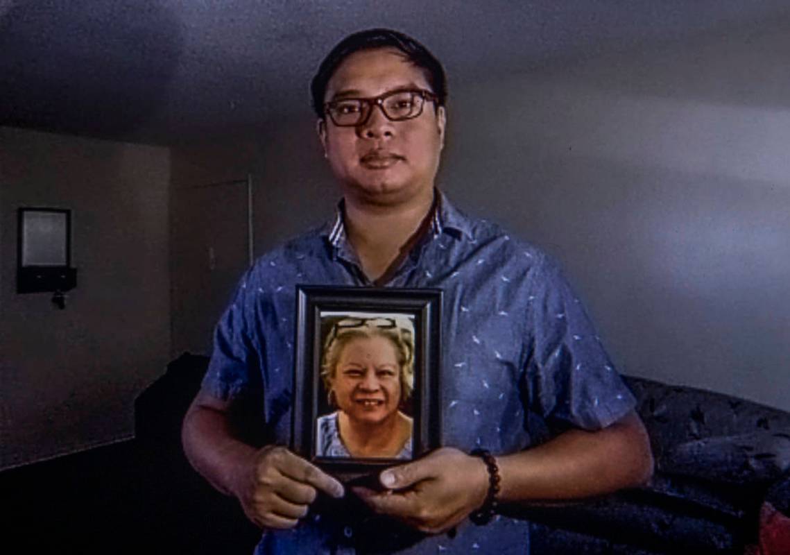 Roderick Alimusa holds a photograph of his mother, Maria Alimusa, at his home in Westminster, C ...