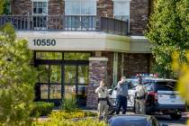 The manager of The Heights of Summerlin gestures beside two Las Vegas Police officers outside, ...