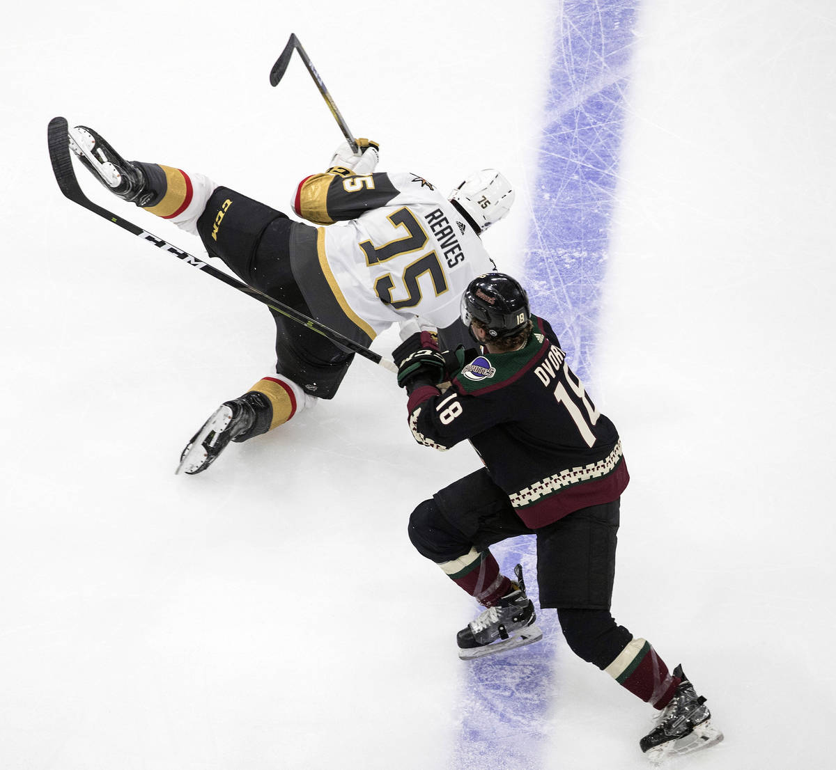 Arizona Coyotes' Kyle Capobianco (75) is checked by Vegas Golden Knights' Ryan Reaves (75) duri ...