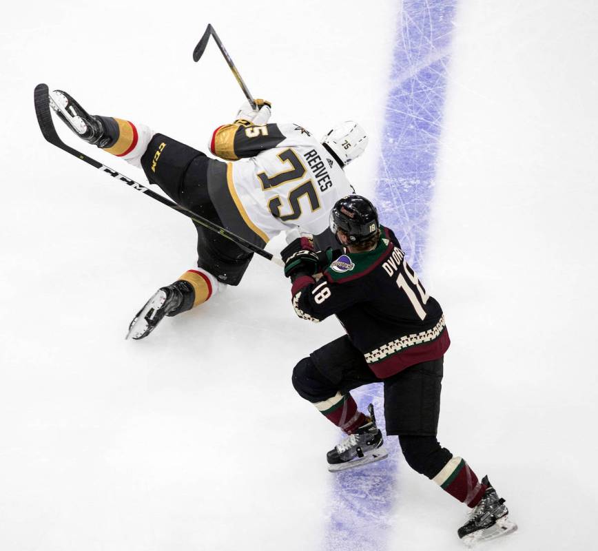 Arizona Coyotes' Kyle Capobianco (75) is checked by Vegas Golden Knights' Ryan Reaves (75) duri ...