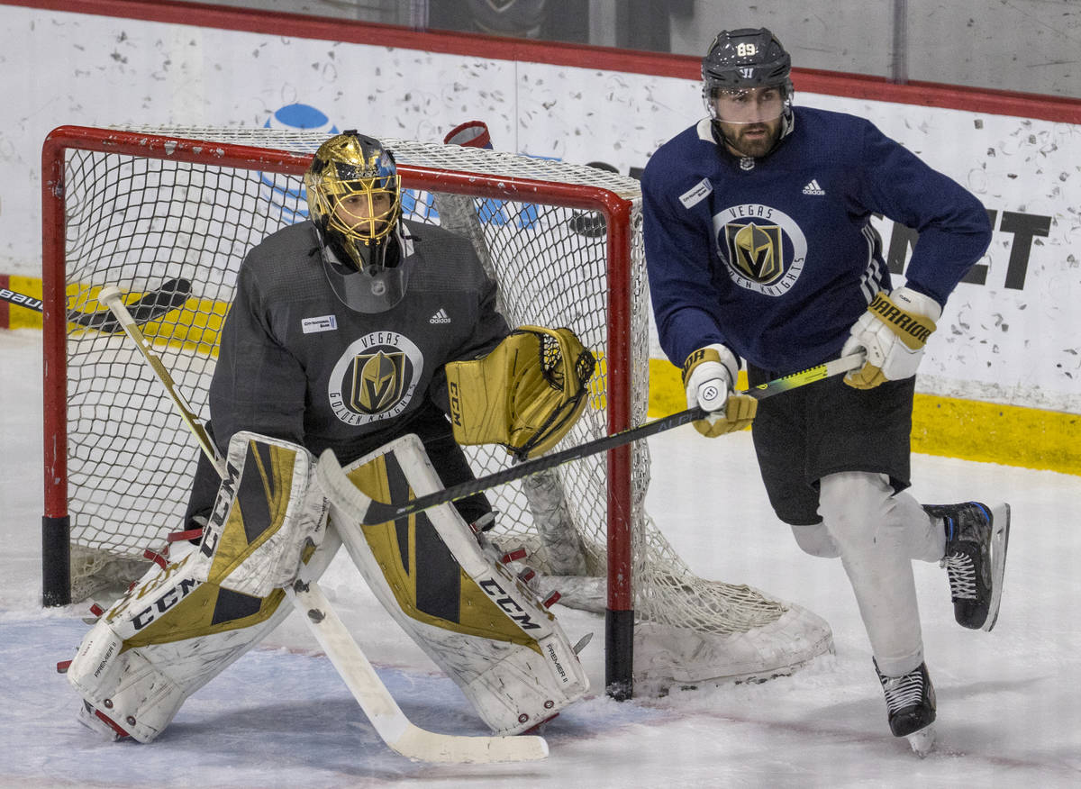 Vegas Golden Knights goaltender Marc-Andre Fleury (29, left) defends the net as right wing Alex ...