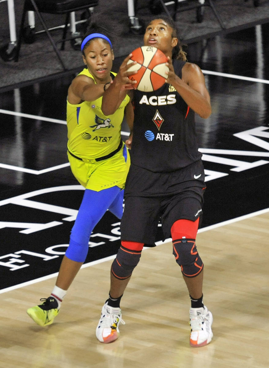 Dallas Wings' Tyasha Harris, left, defends against Las Vegas Aces' Angel McCoughtry during the ...