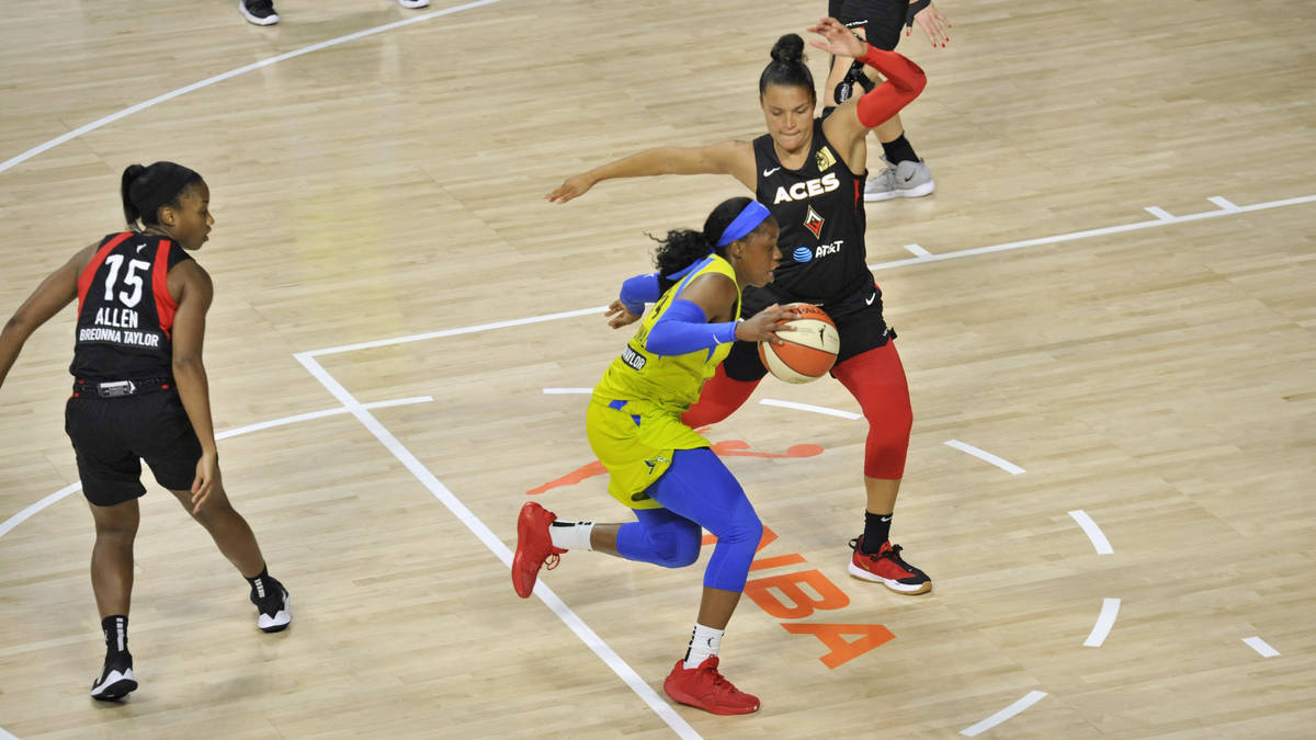 Dallas Wings' Tyasha Harris, center, moves between Las Vegas Aces' Lindsay Allen (15) and Kayla ...
