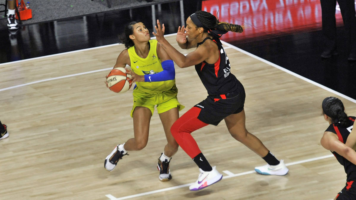 Dallas Wings' Satou Sabally, left, looks to shoot as Las Vegas Aces' A'ja Wilson defends during ...