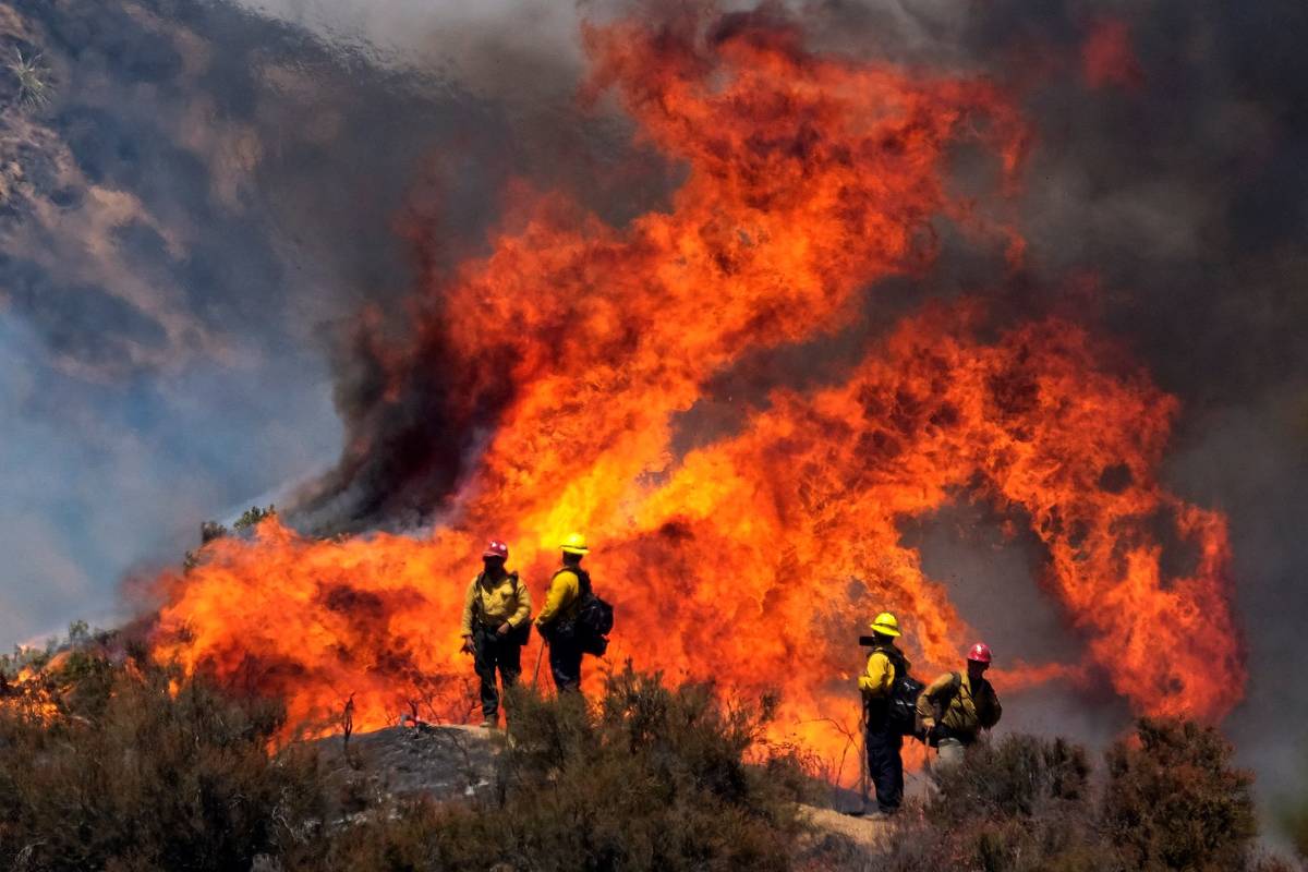 Firefighters watch the Apple Fire in Banning, Calif., Sunday, Aug. 2, 2020. (AP Photo/Ringo H.W ...