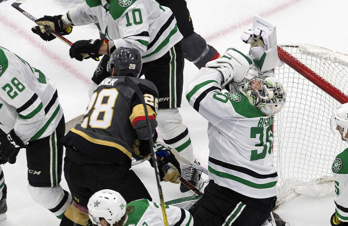 Dallas Stars goalie Ben Bishop (30) is hit by Vegas Golden Knights' William Carrier (28) during ...