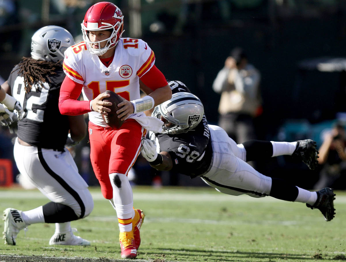 Kansas City Chiefs quarterback Patrick Mahomes (15) sheds tackle by Oakland Raiders defensive e ...